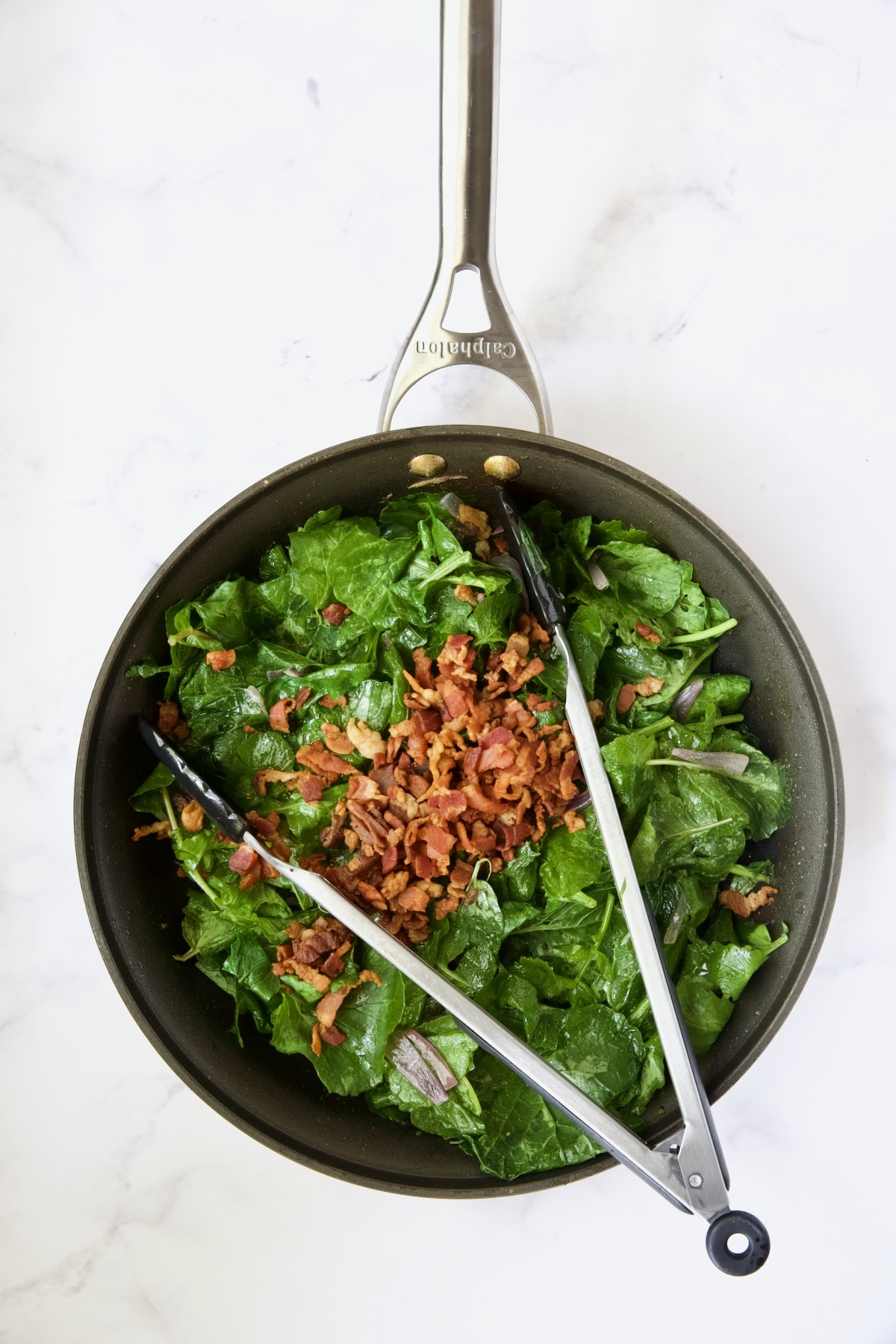 Slightly wilted radish greens in skillet with bacon.