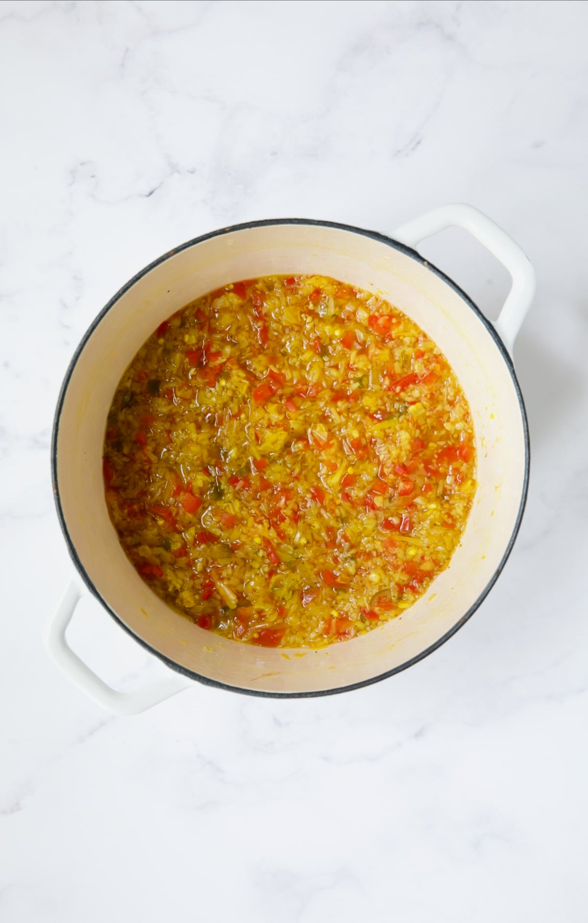 Ingredients for ramp relish in white Dutch oven after being cooked.