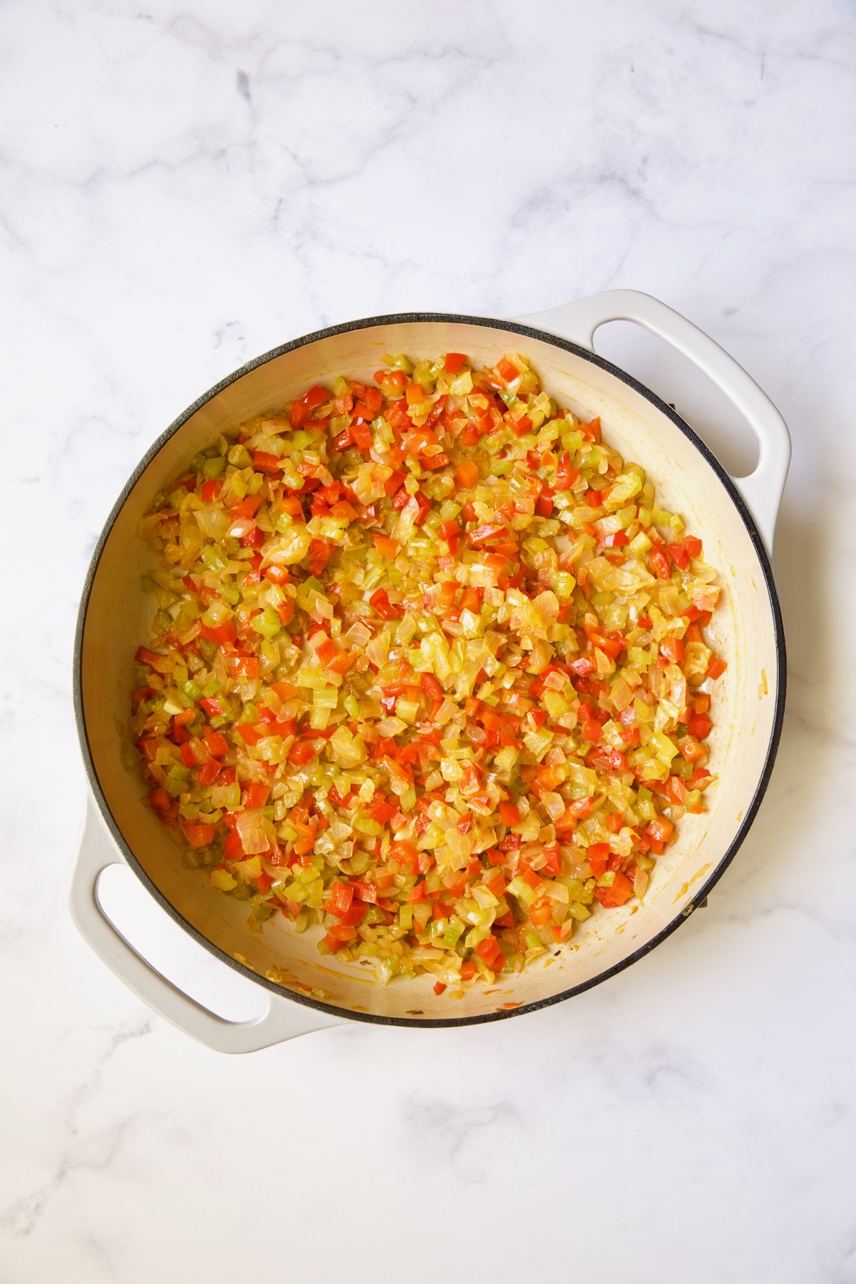 Sauteed bell peppers and onions in white enamel cast iron skillet.