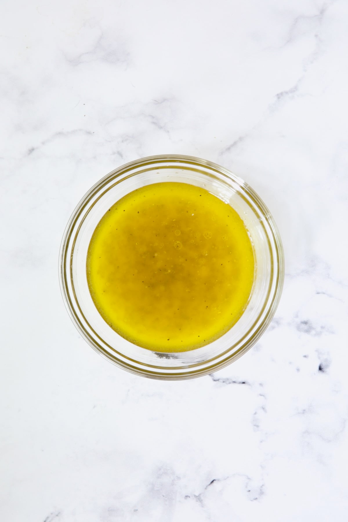 Lemon dressing for salad in glass bowl.