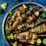 Mojo-Marinated Pork Skewers on metal tray garnished with cilantro.