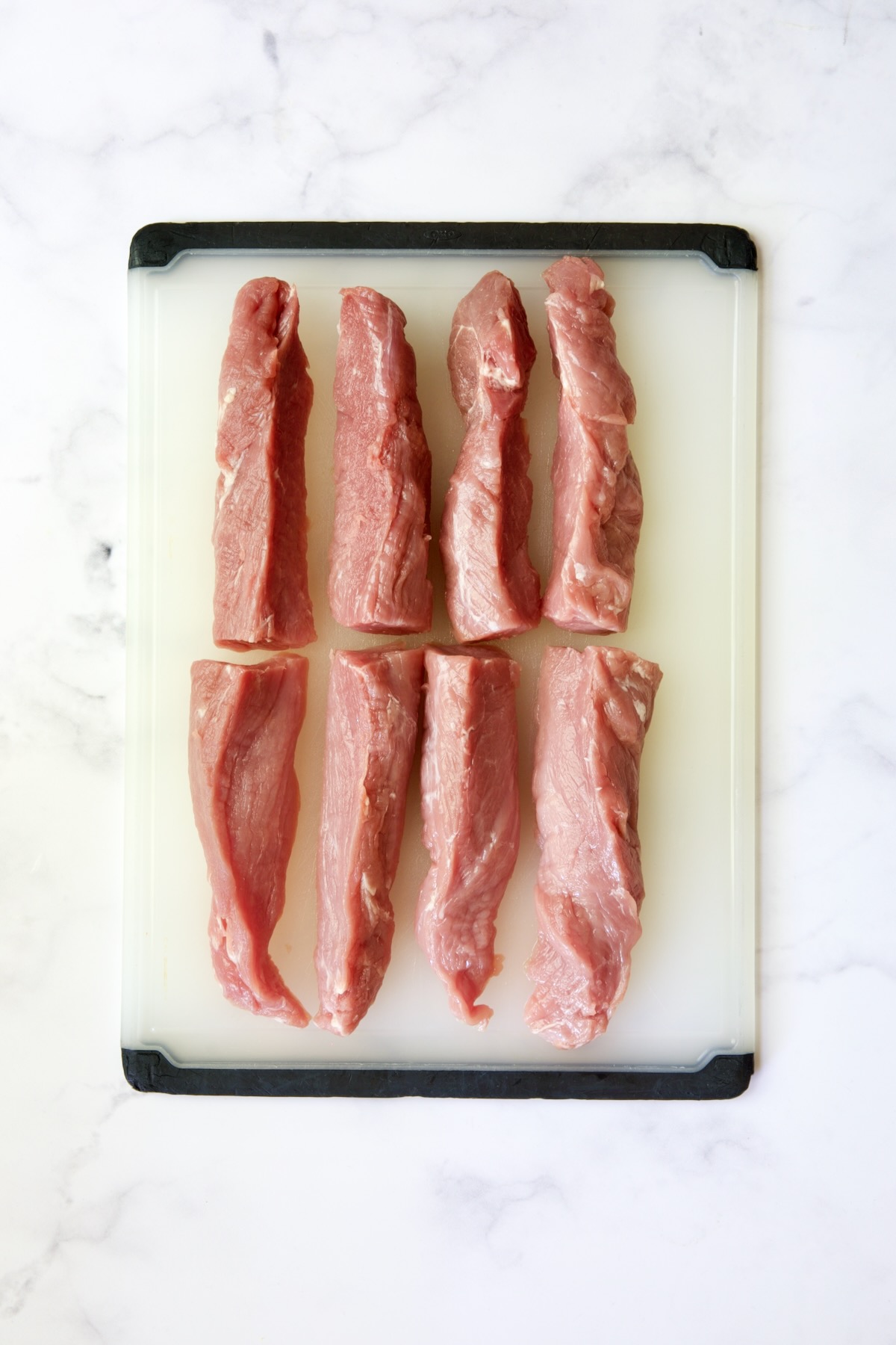 Pork tenderloins cut into eight long strips.