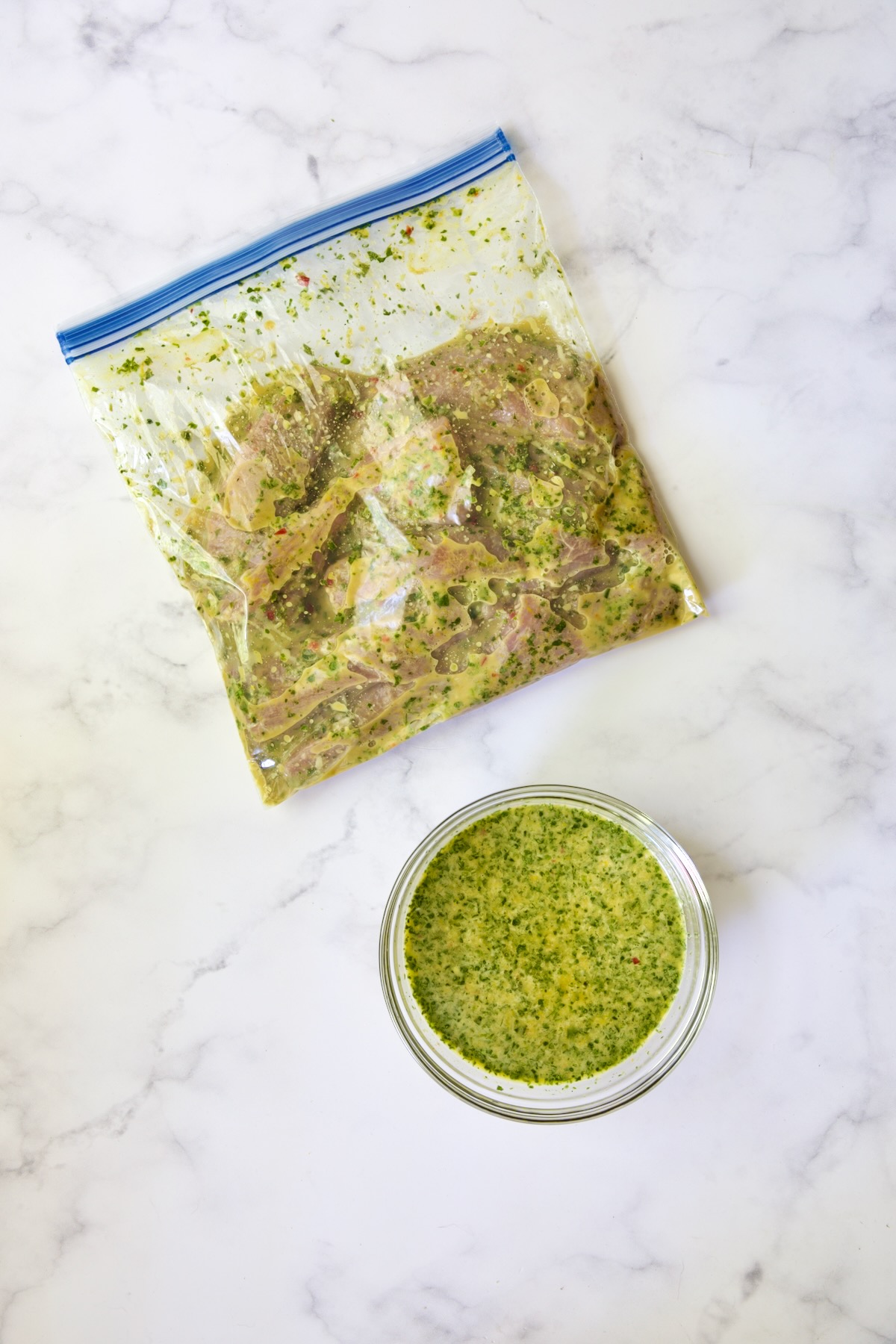 Pork in plastic zipper-top bag with marinade and bowl of marinade.