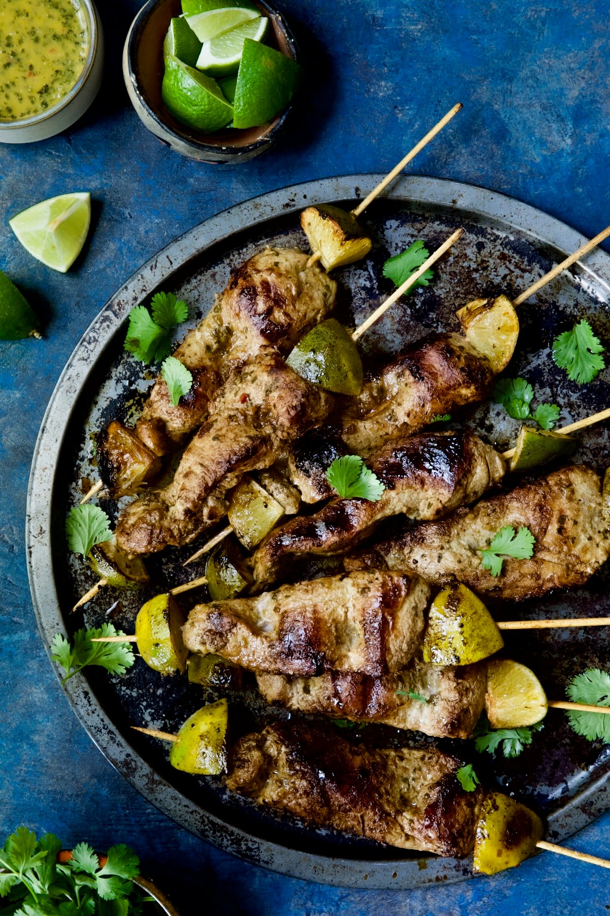 Mojo-Marinated Pork Skewers on metal tray garnished with cilantro.