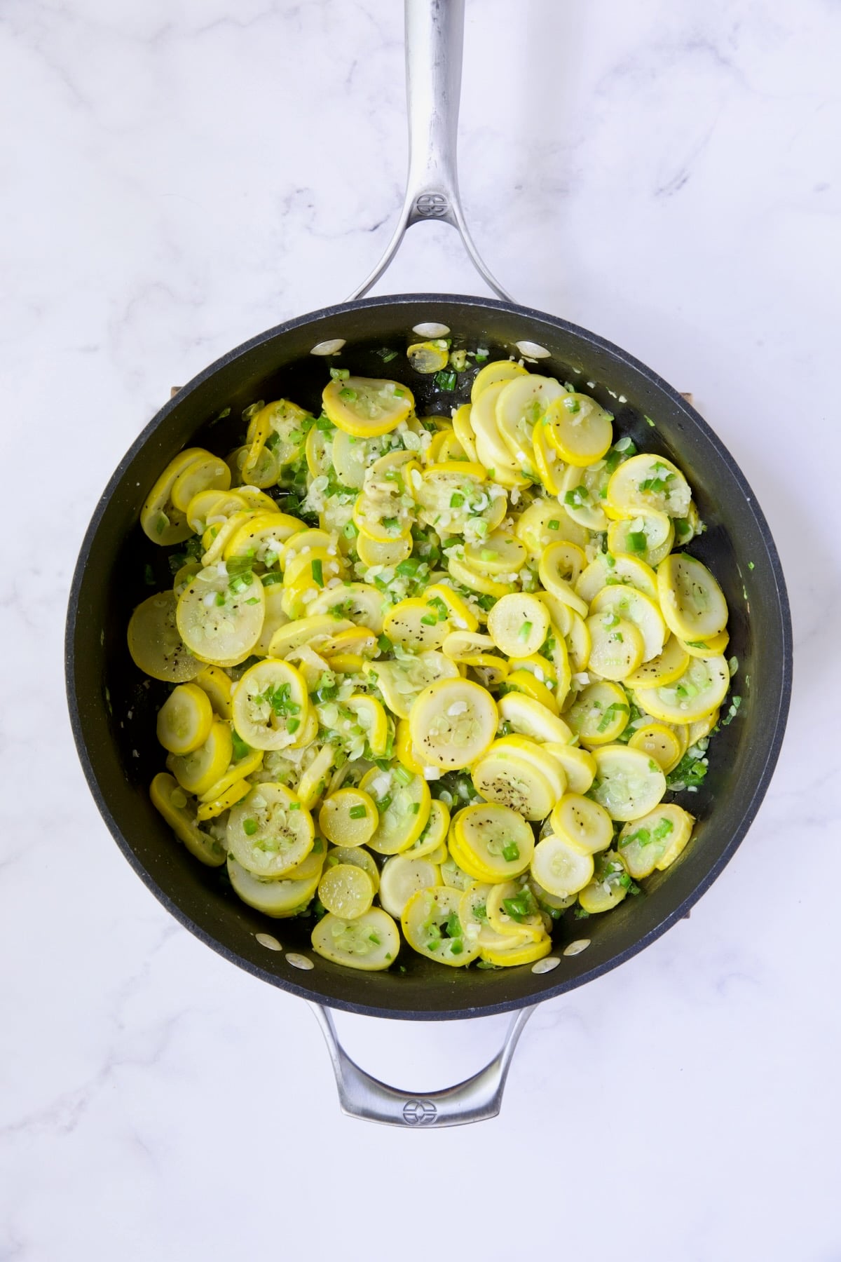 Sauteed yellow / summer squash and scallions in nonstick skillet.