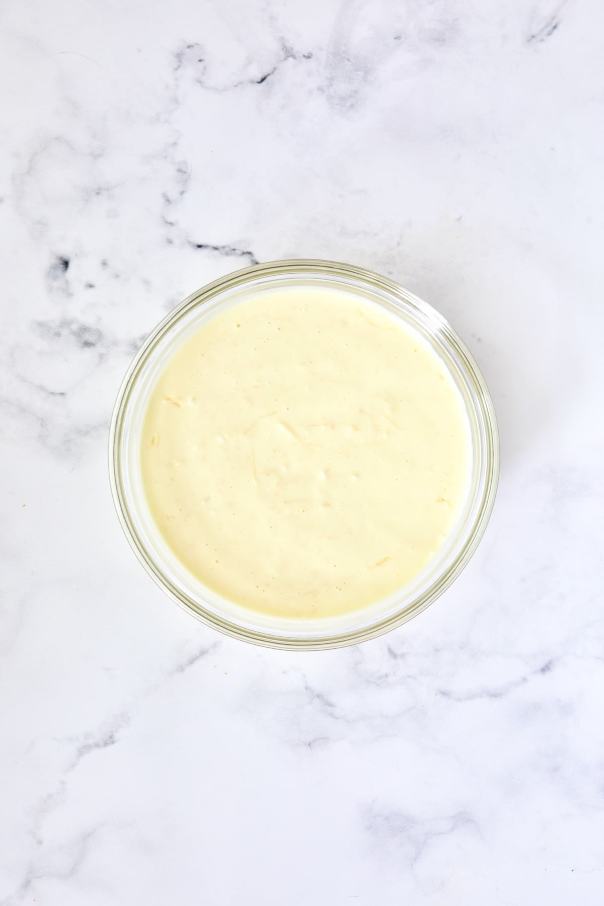 Mayonaisse, egg, cream cheese and Parmesan cheese combination in glass bowl.