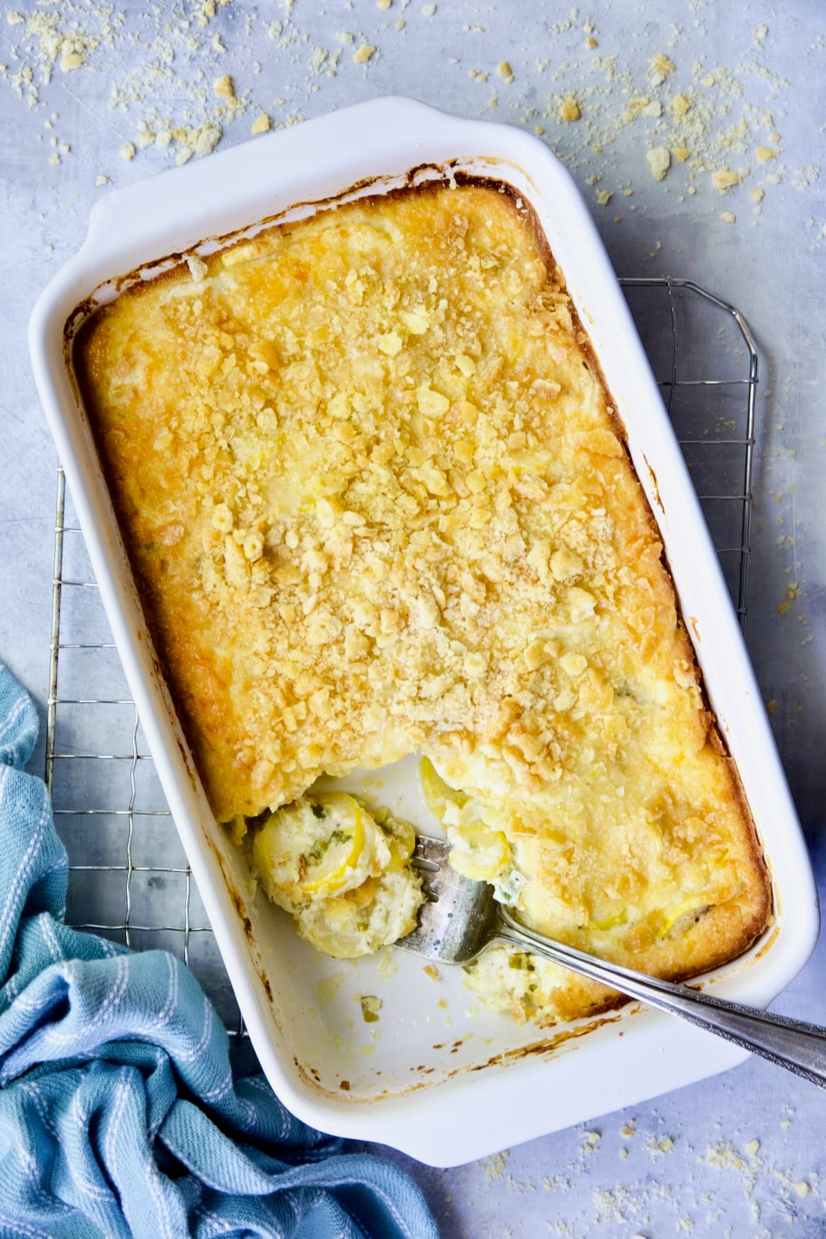 Southwestern Summer Squash Casserole on cooling rack with blue striped towel with a piece removed.