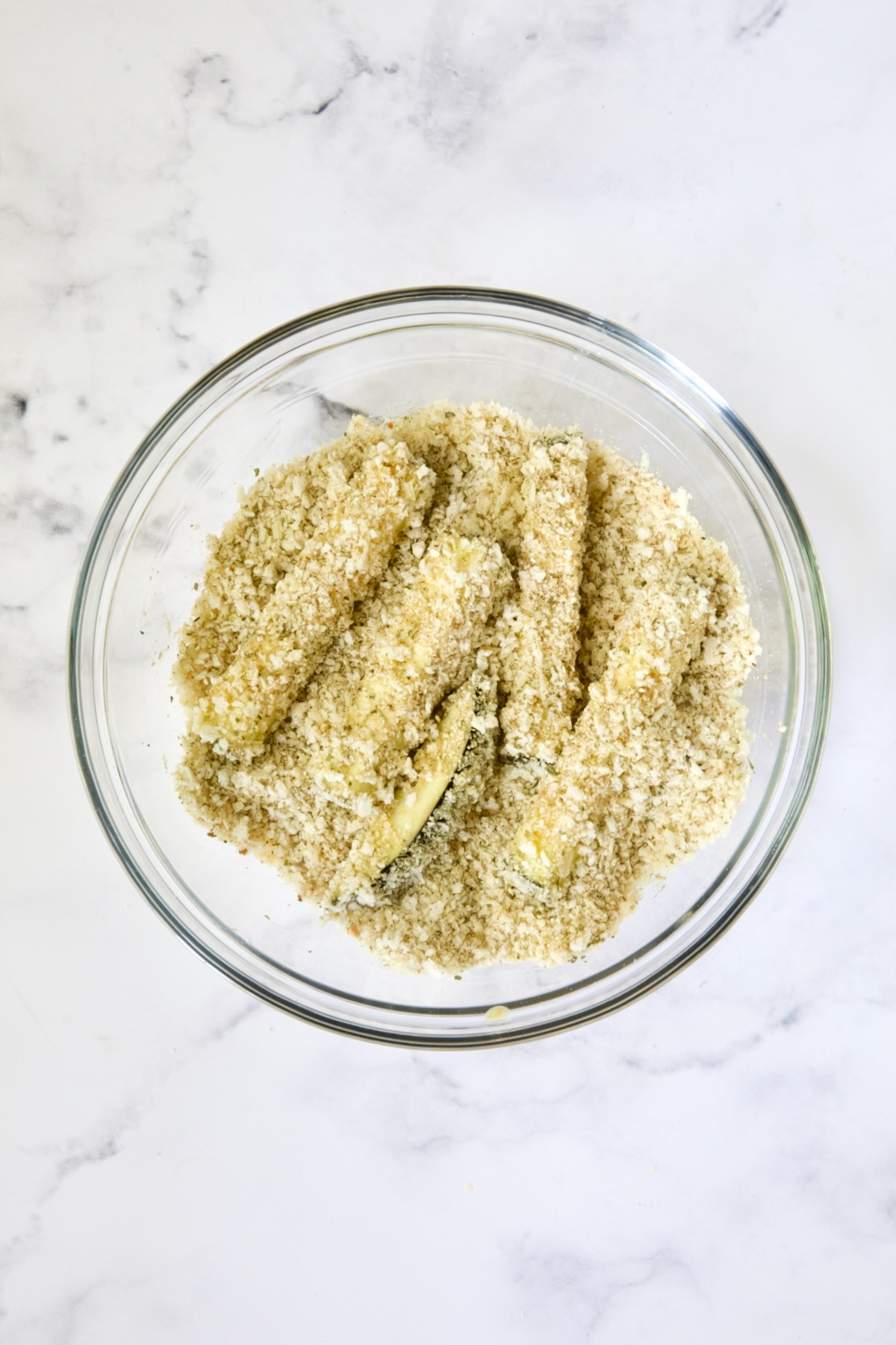 Eggplant fries in breadcrumb coating in glass bowl.