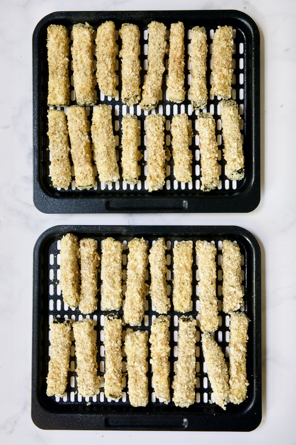Two trays of eggplant fries before being fried in air fryer.
