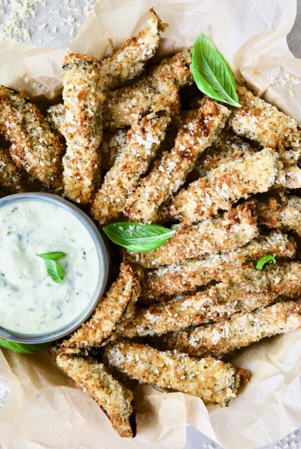 Air Fryer Eggplant Fries with Garlic Basil Aioli garnished with fresh basil.