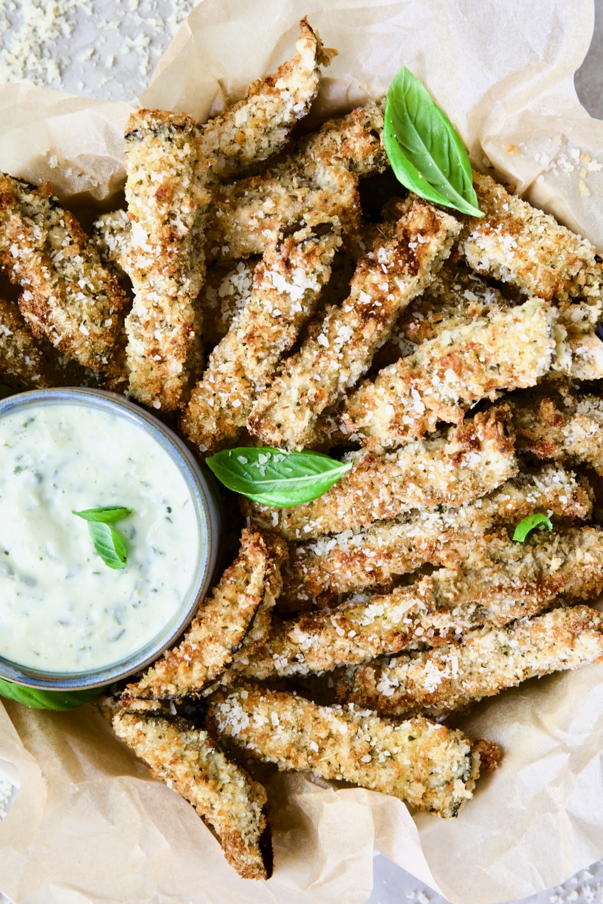 Air Fryer Eggplant Fries with Garlic Basil Aioli garnished with fresh basil.