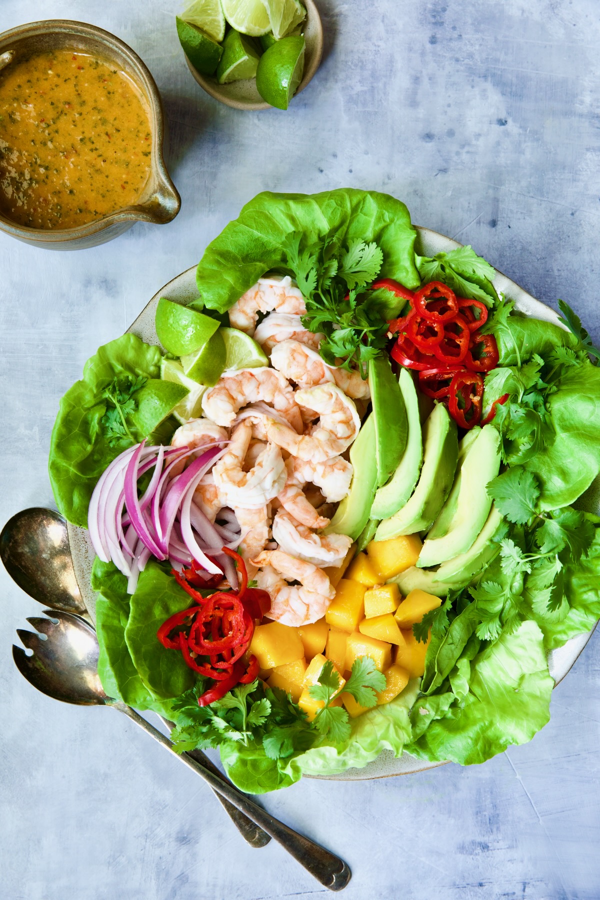 Butter Lettuce Salad with Shrimp, Mango and Avocado with vinaigrette and lime wedges.