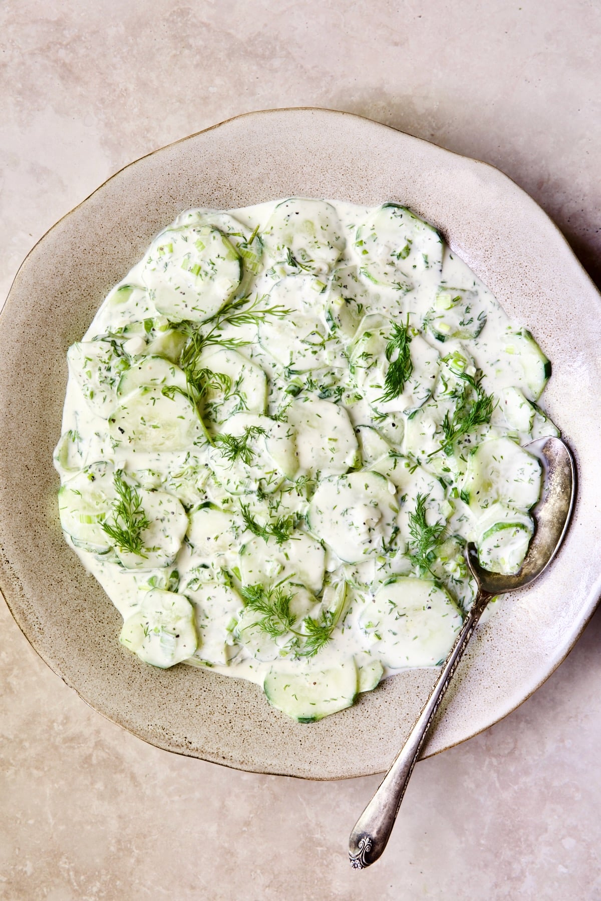 Yogurt Ranch Cucumber Salad in serving bowl with antique serving spoon.