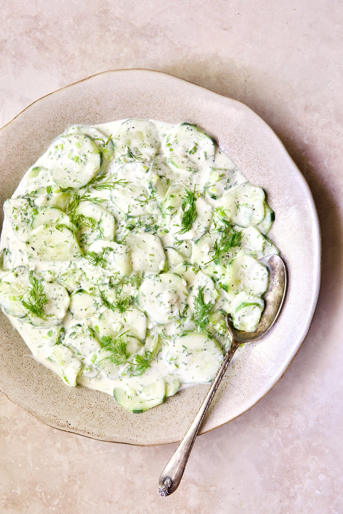 Yogurt Ranch Cucumber Salad in salad bowl with antique serving spoon.