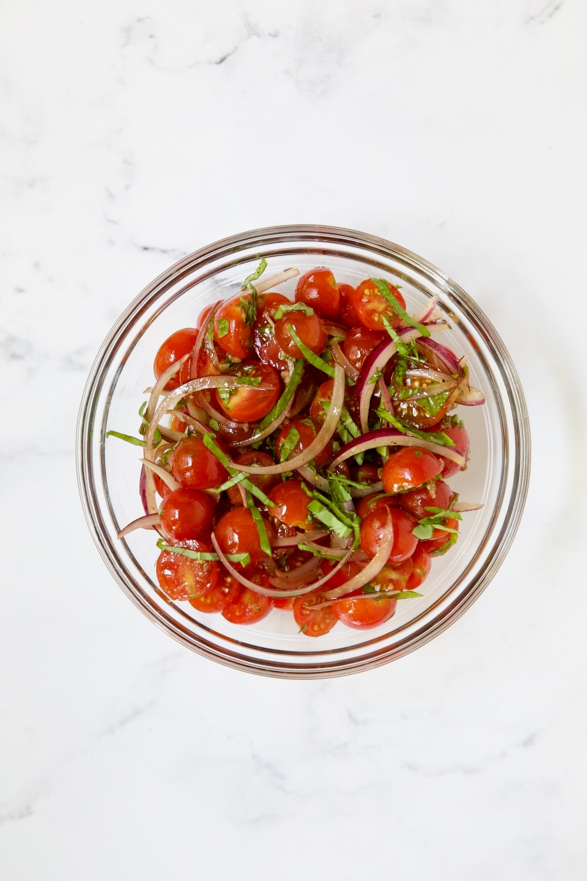 Cherry tomato salad in glass bowl.