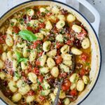 Gnocchi with Cherry Tomato Puttanesca Sauce garnished with fresh parsley, basil and Parmesan cheese.