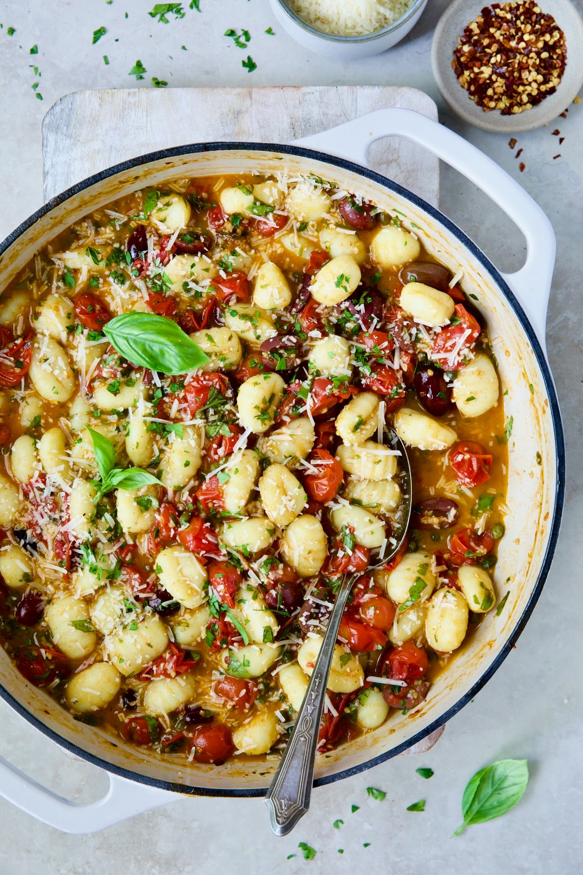 Gnocchi with Cherry Tomato Puttanesca Sauce garnished with fresh parsley, basil and Parmesan cheese.