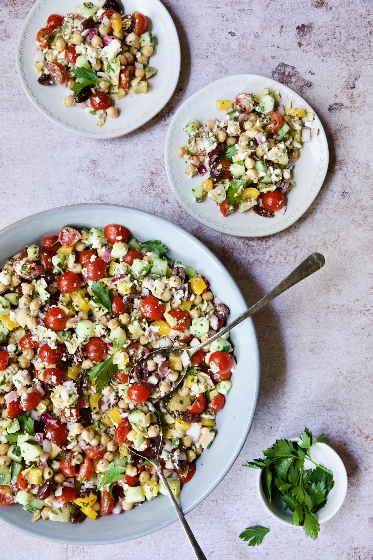 Mediterranean Chopped Salad with Chickpeas being served up from bowl on two small plates.