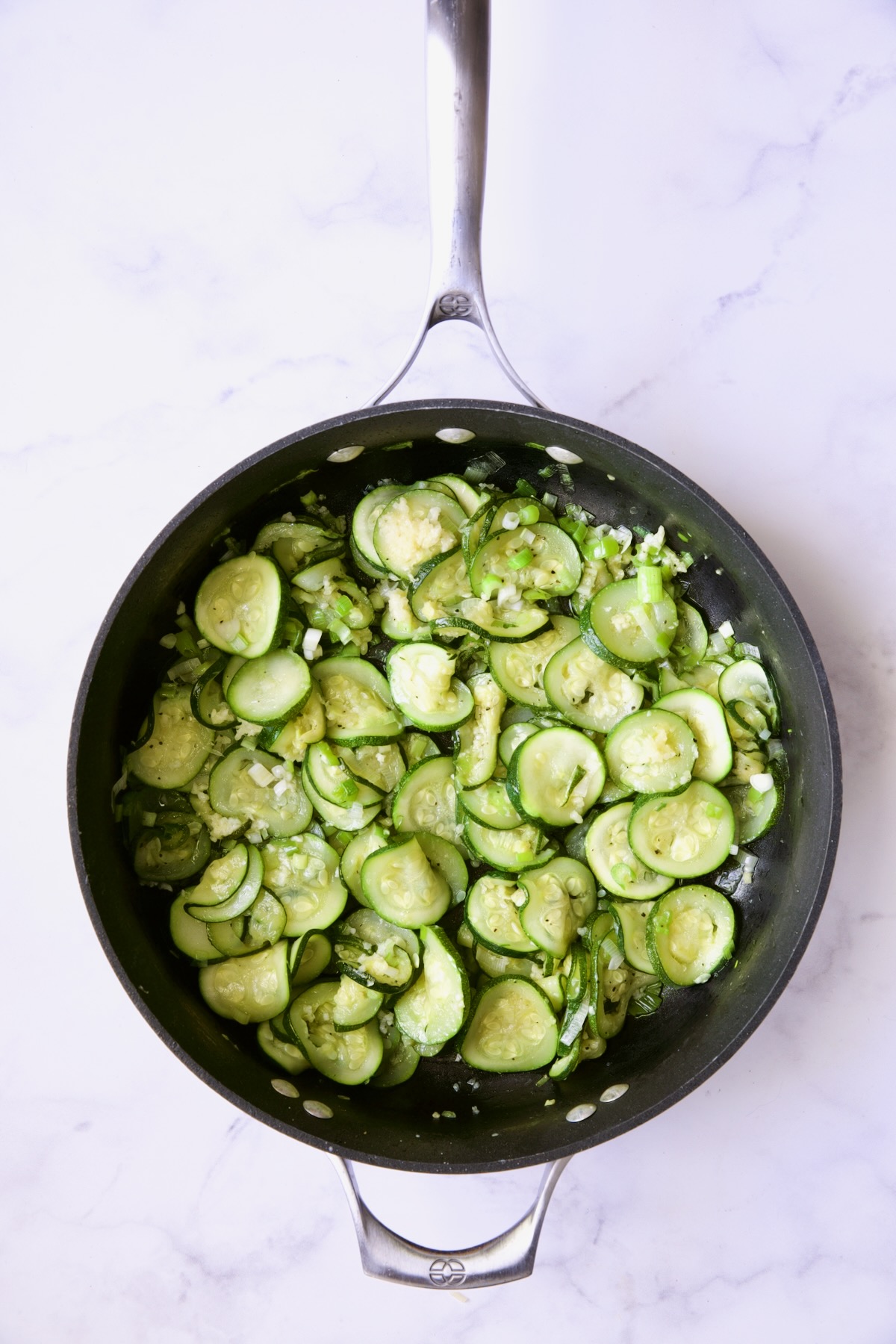 Cooked zucchini slices in nonstick skillet.