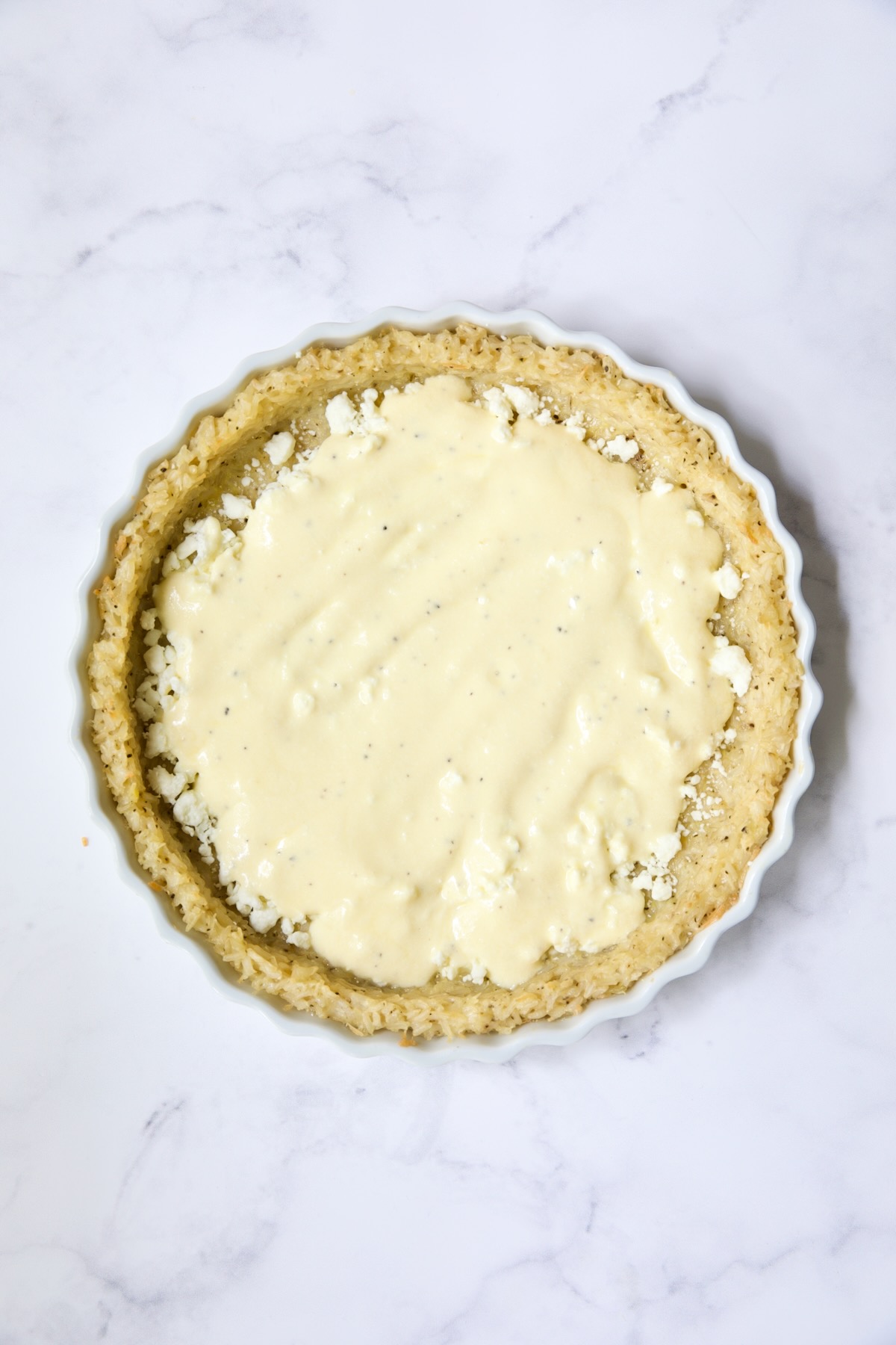 Half the ricotta custard spread over feta cheese in pie crust.