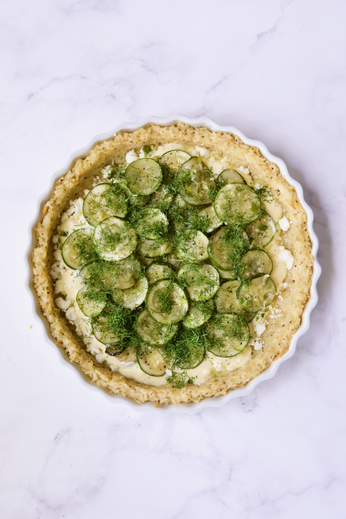 Zucchini in pie with dill scattered over the top.