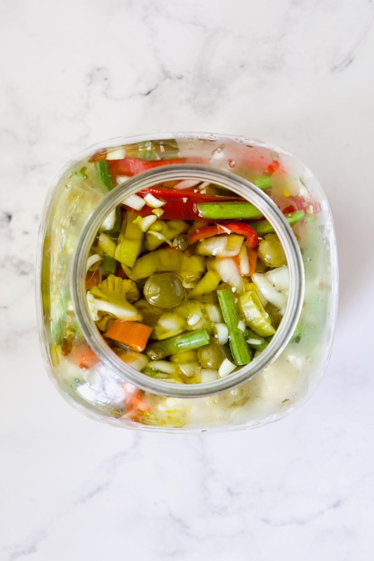 Giardiniera (Italian Pickled Vegetables) in glass jar after hot brine is added.
