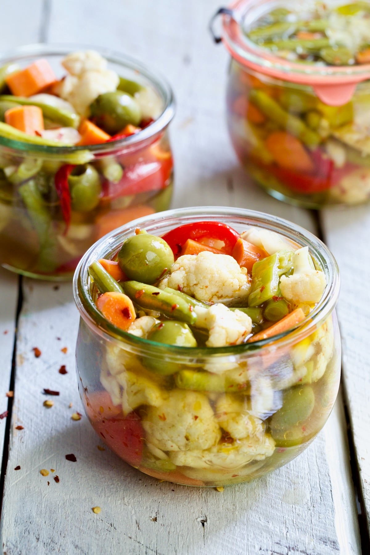 Three jars of Giardiniera (Italian Pickled Vegetables).