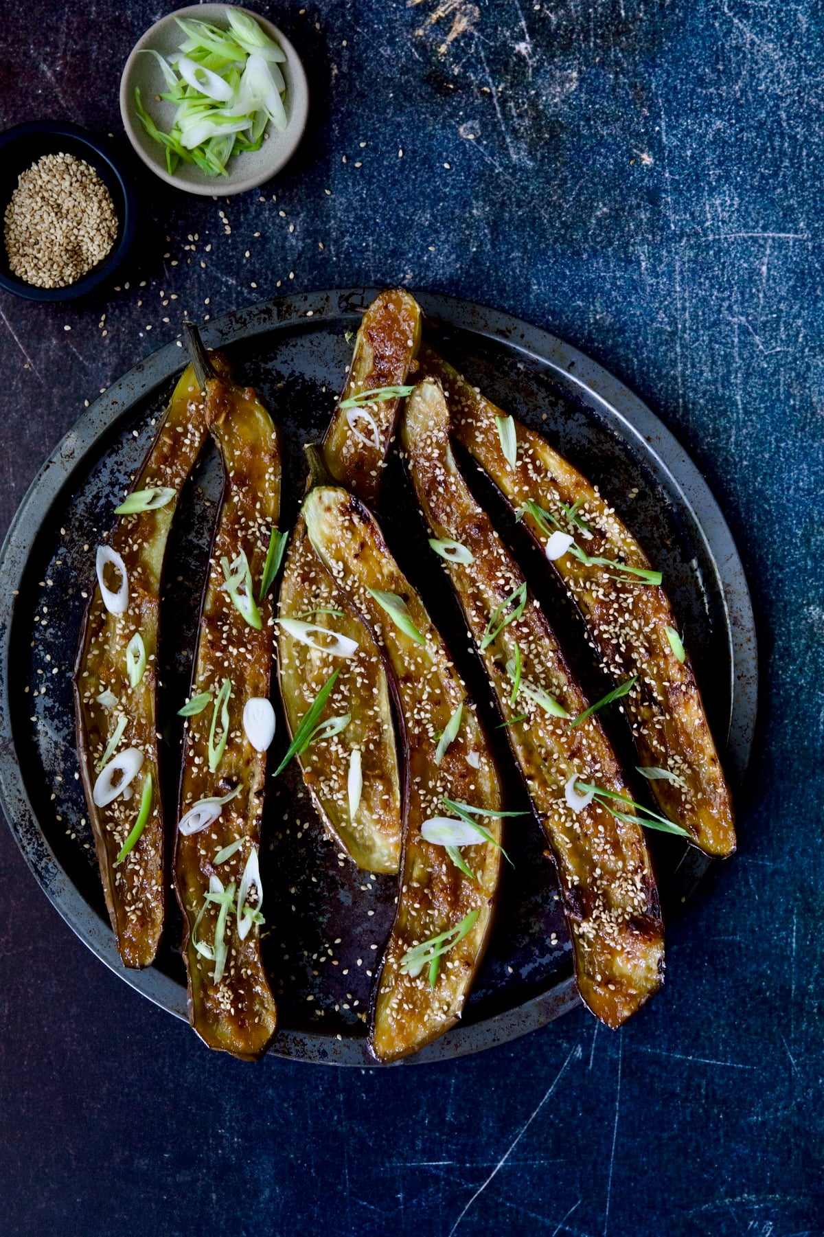 Miso-Glazed Eggplant on metal tray with sesame seeds and scallions.