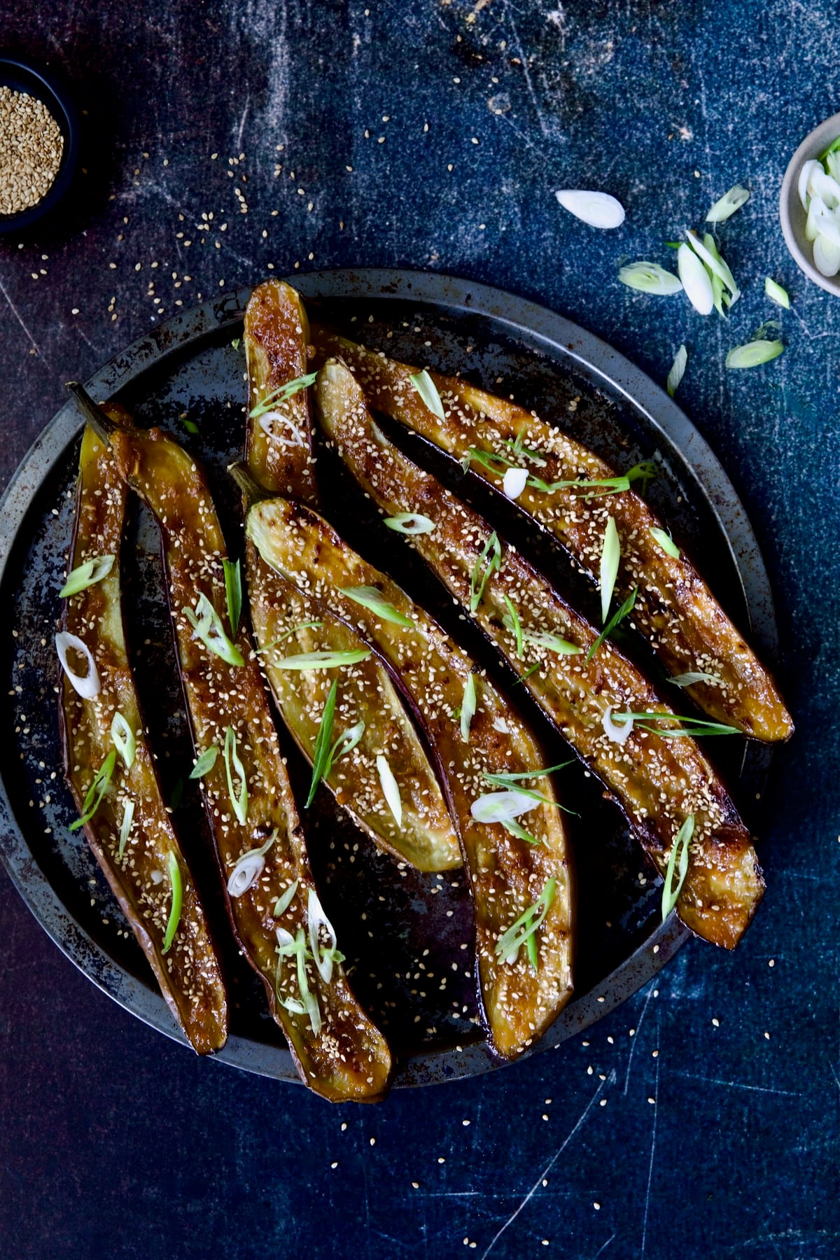 Miso-Glazed Eggplant with scallions and sesame seeds scattered about.