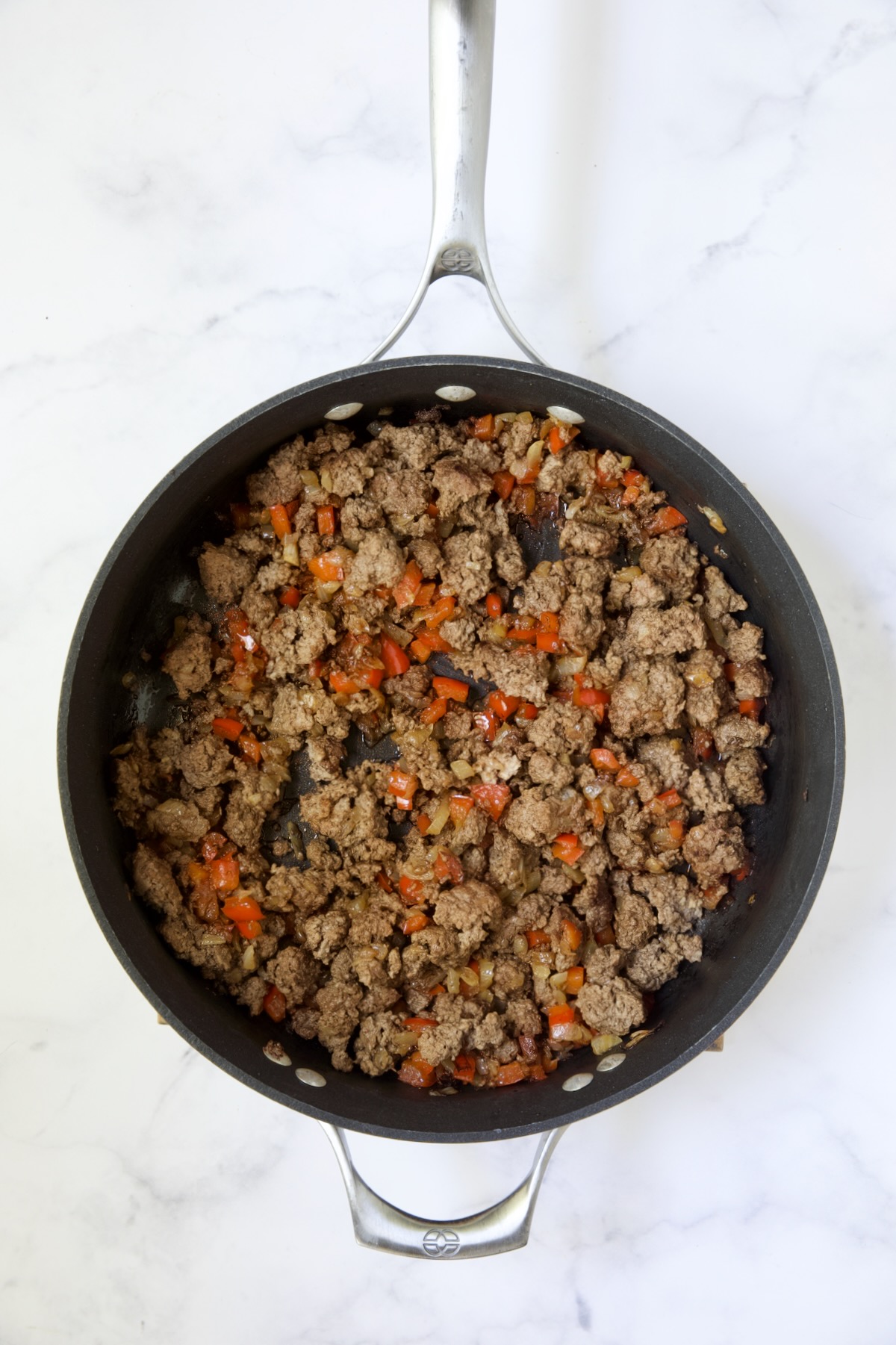 Cooked ground beef and red bell pepper in nonstick skillet.