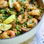 Brown Rice Paella with Shrimp and Chorizo with lemon wedges.