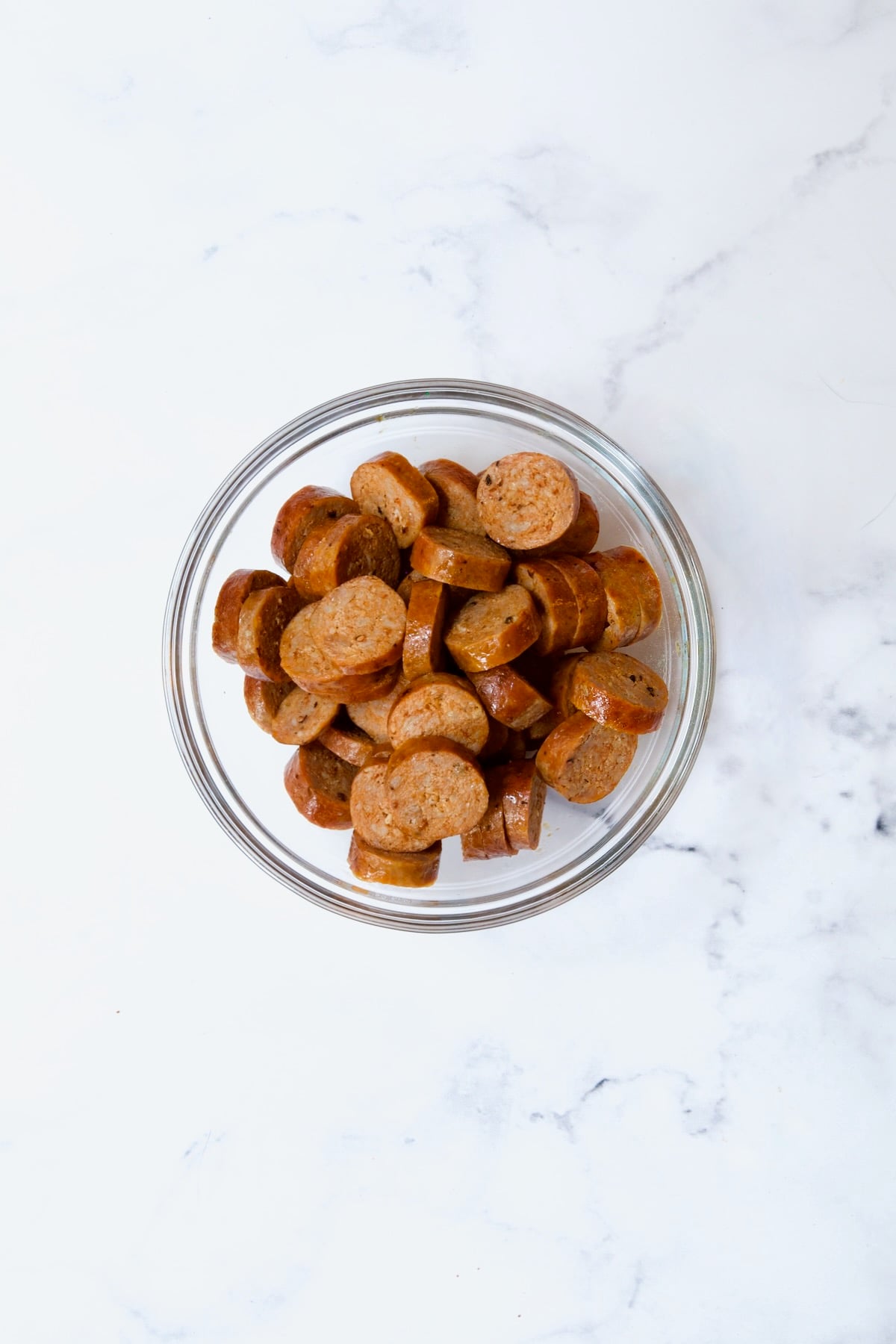 Cooked sliced chorizo in glass bowl.