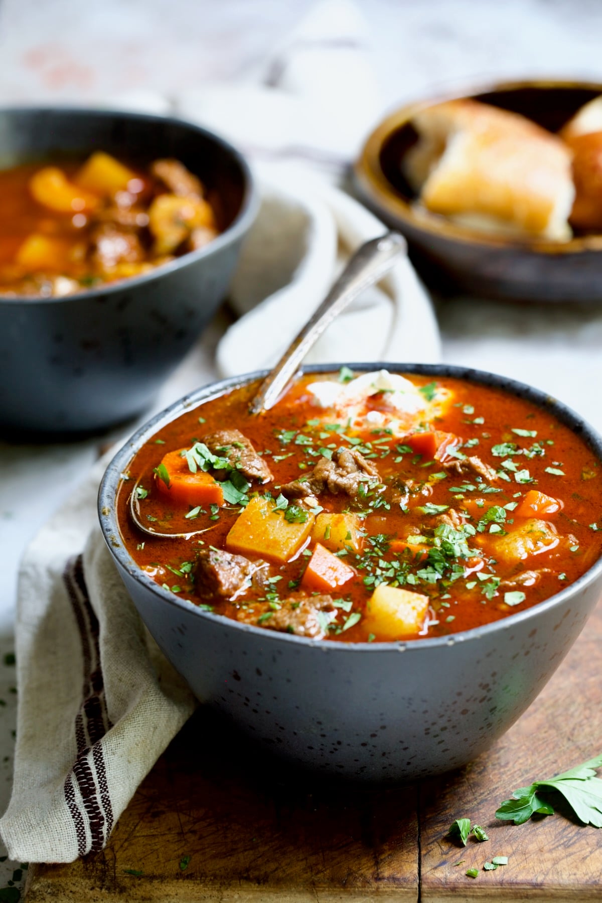 Bowl of Traditional Hungarian Goulash Soup Recipe garnished with fresh parsley.