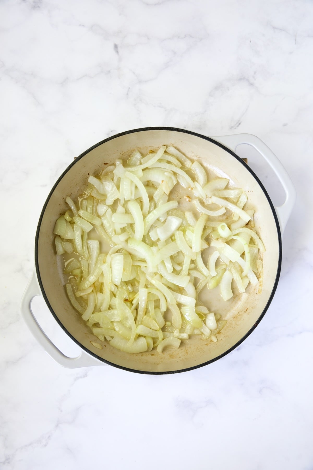 Onions in white enamel cast iron skillet.