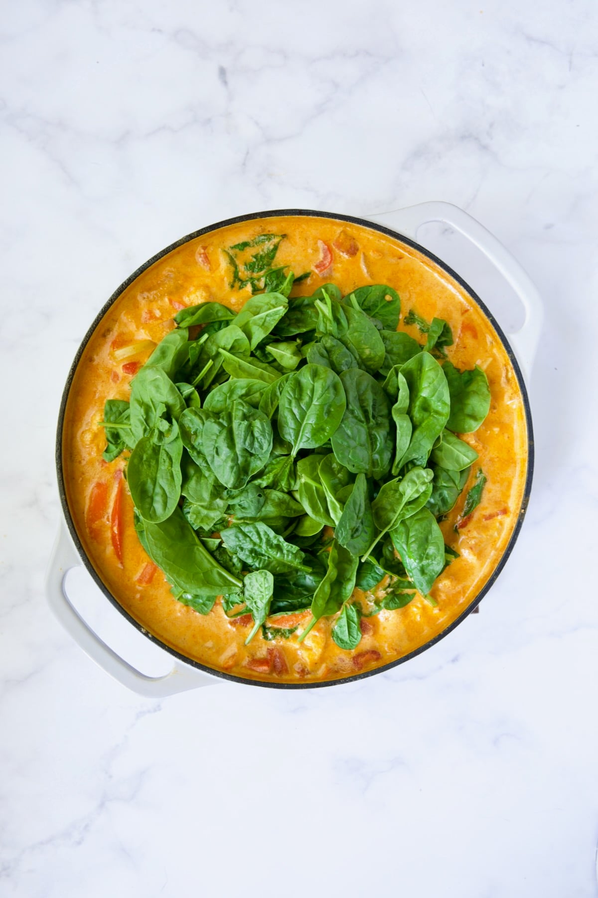 Vegetable curry process shot with spinach added.