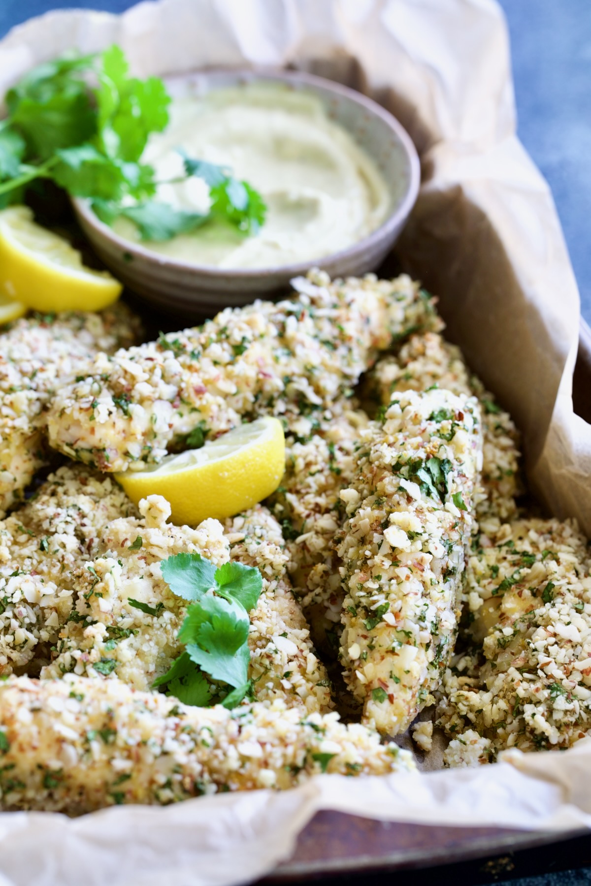 Almond-Crusted Chicken Tenders with Lemon Curry Mayonnaise in parchment paper-lined pan.