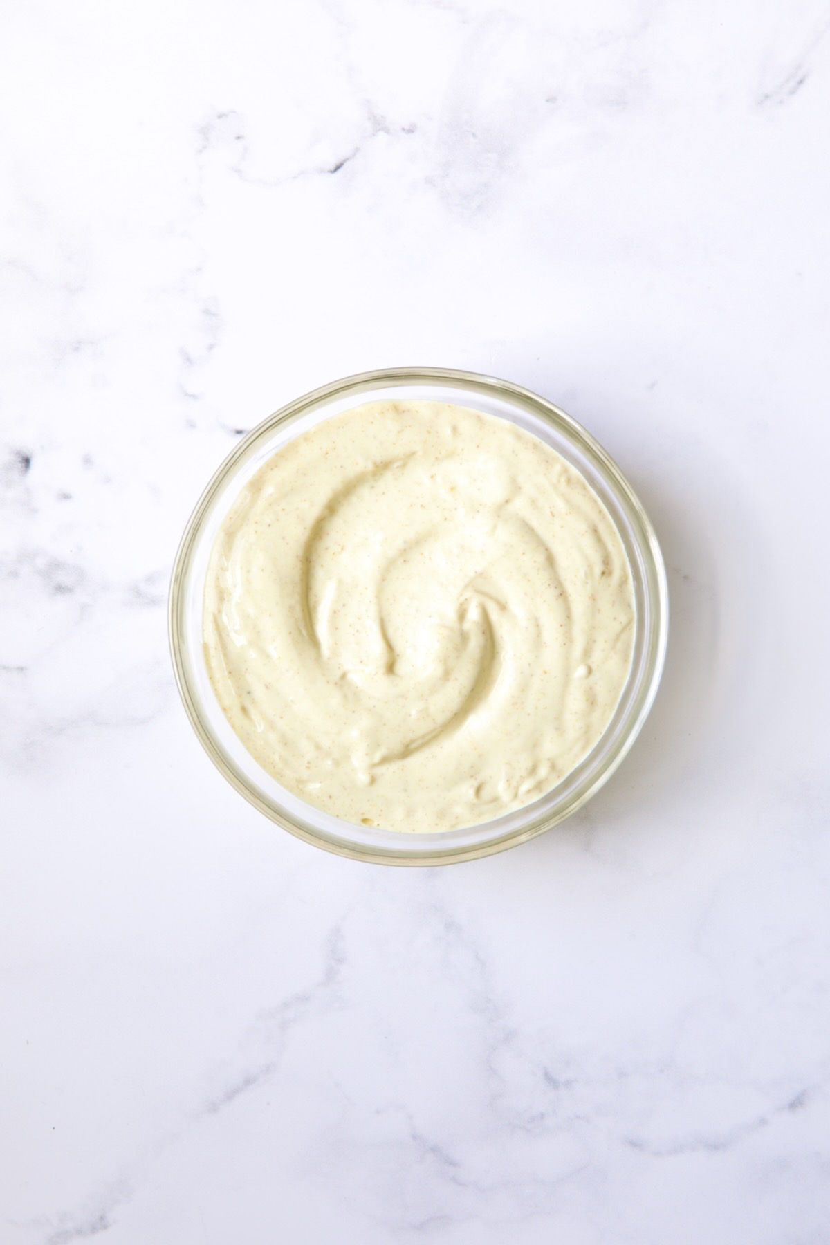 Bowl of Lemon Curry Mayonnaise in glass bowl.