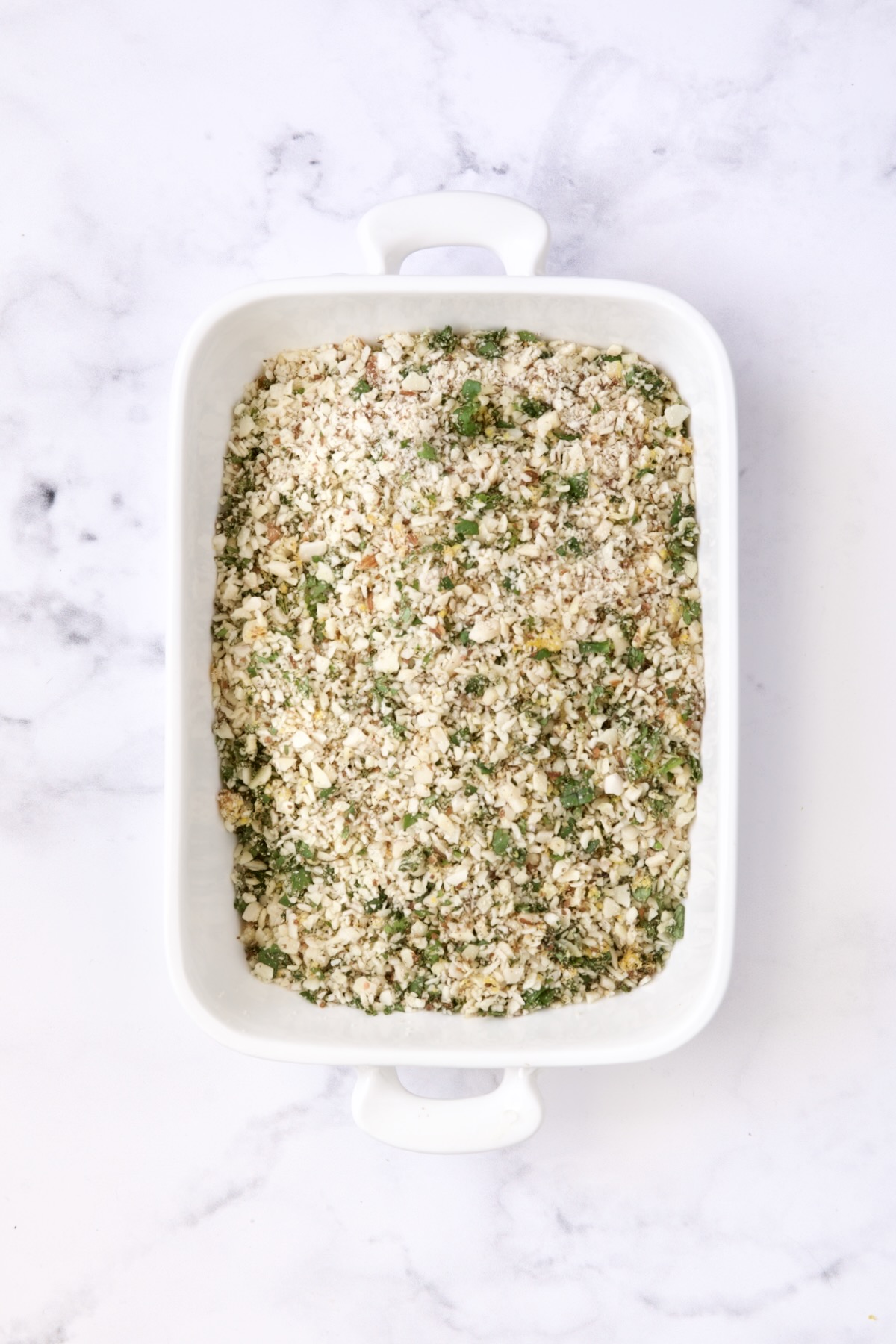 Almond coating in white rectangular baking pan.