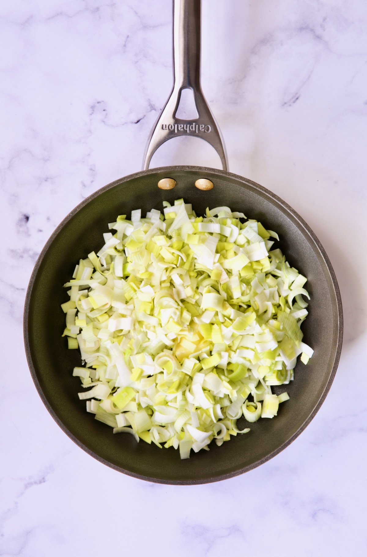 Uncooked leeks in nonstick skillet.