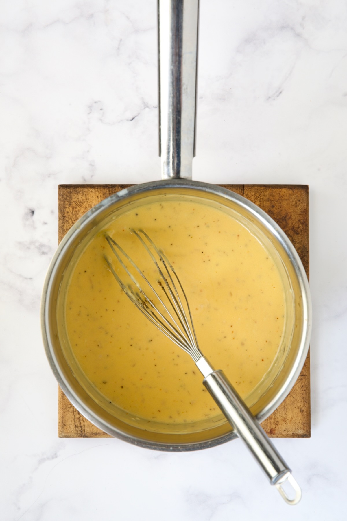 Cheese sauce in stainless steel saucepan.