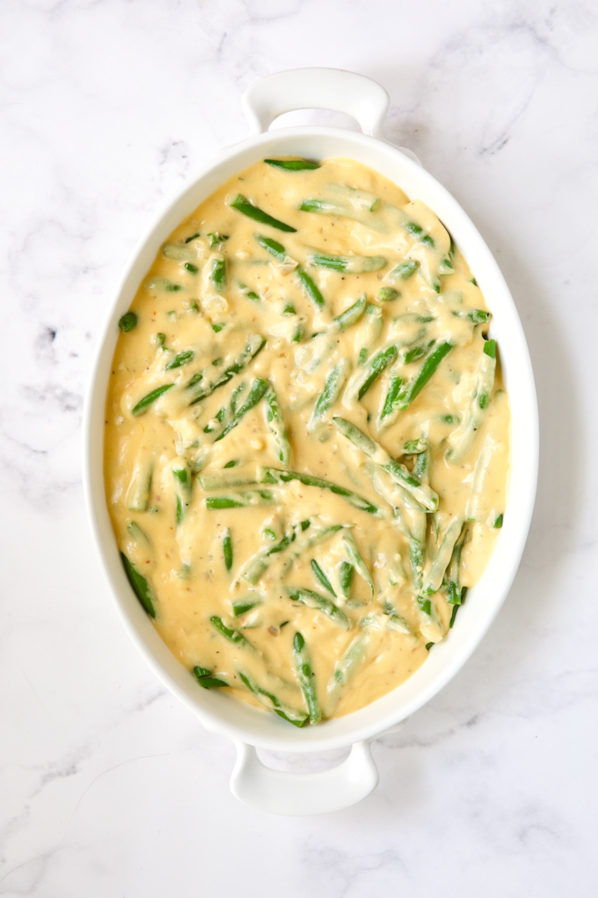Green beans with cheese sauce poured over.