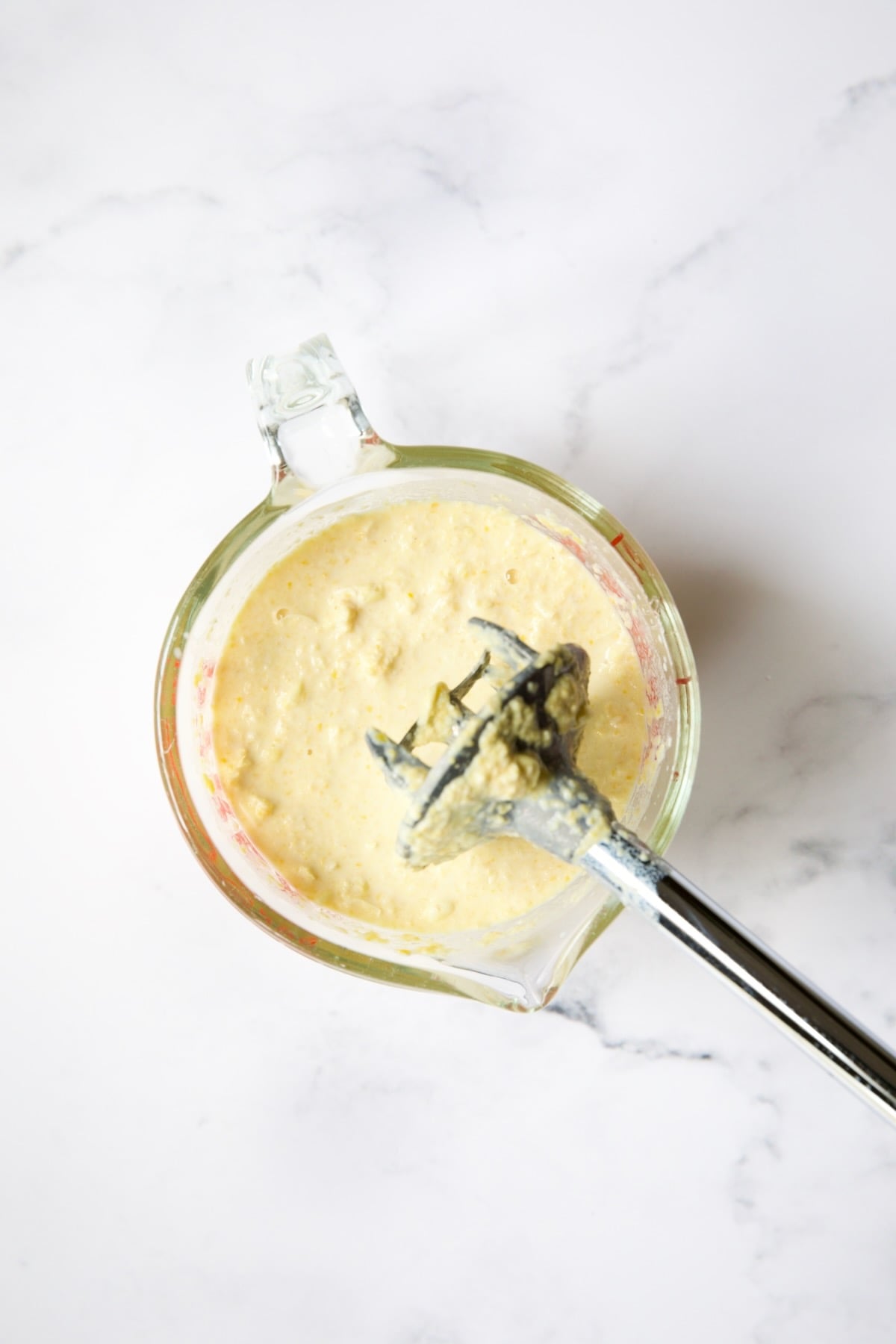 Pureed corn in glass measuring cup.