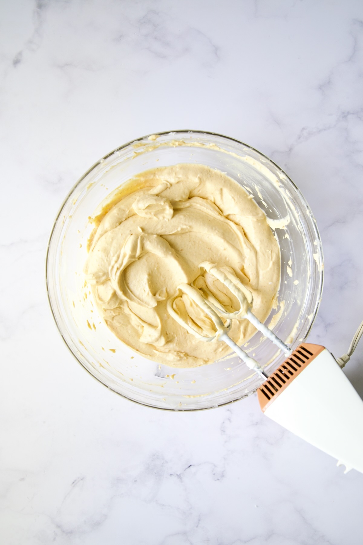 Pumpkin cheesecake filling in glass bowl.