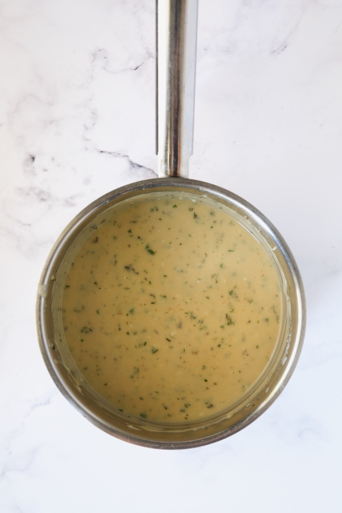 Finished sauce in stainless steel saucepan.