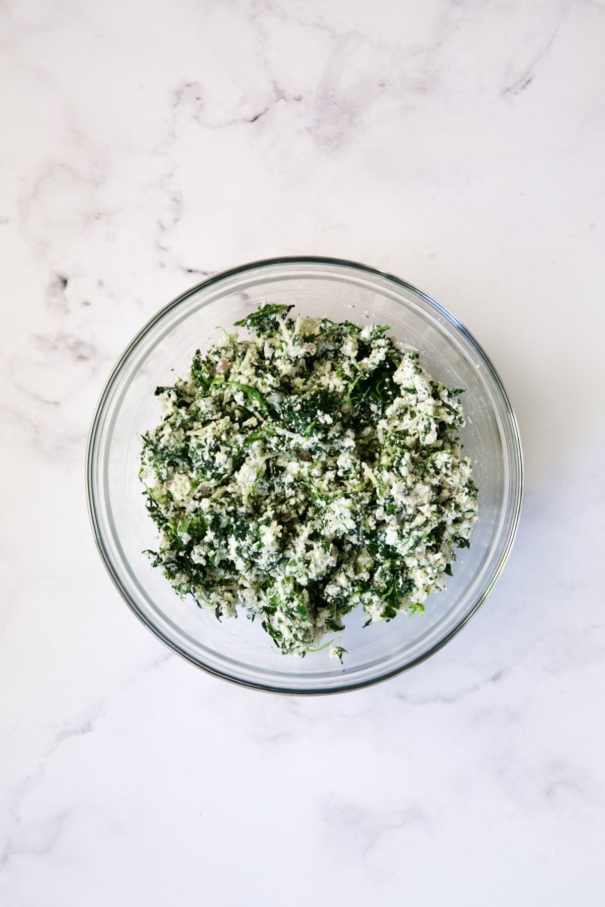 Spinach and ricotta filling in glass bowl.