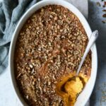 Sweet Potato Souffle in oval baking dish with serving spoon.