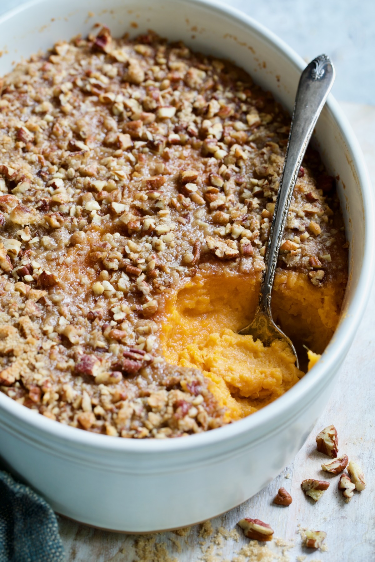 Sweet Potato Souffle in oval baking dish with serving spoon.