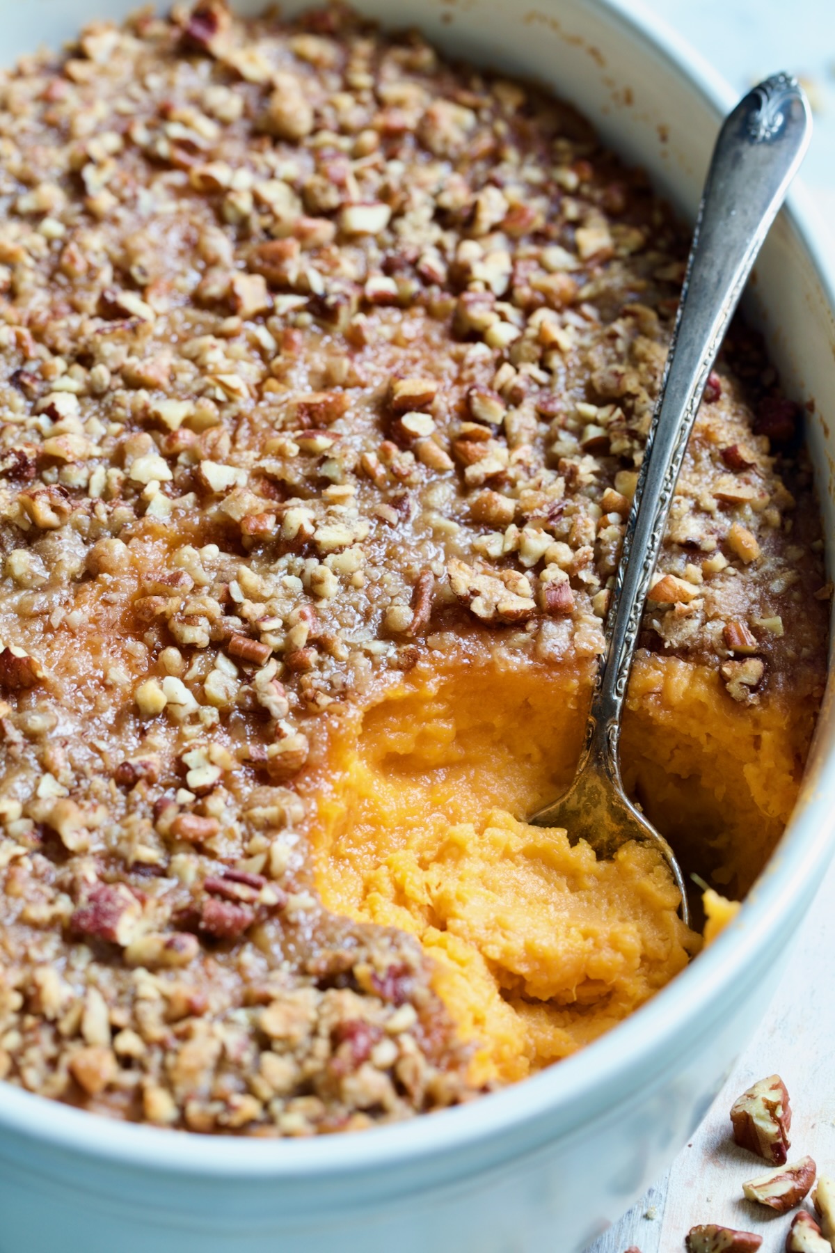 Sweet Potato Souffle in oval baking dish with serving spoon.