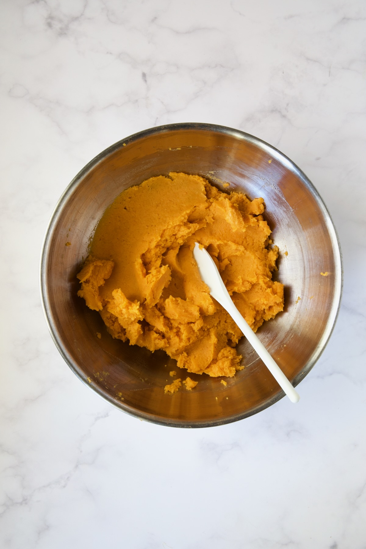 Mashed sweet potatoes in stainless steel bowl.