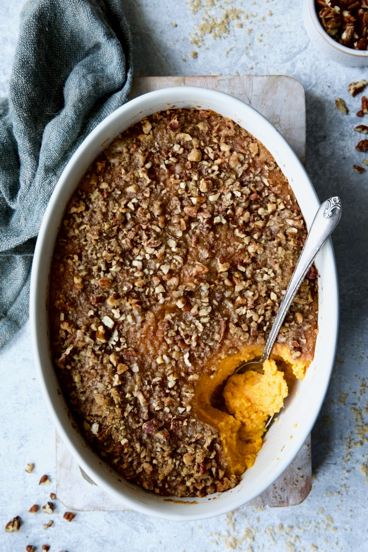 Sweet Potato Souffle in oval baking dish with serving spoon.